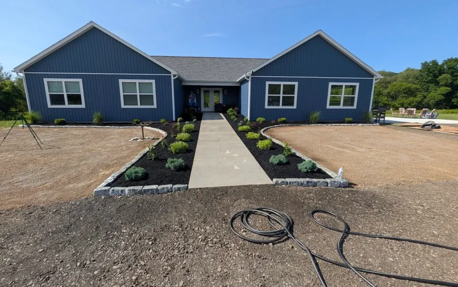New plantings, seeded lawn, mulch and granite cobblestone edging
